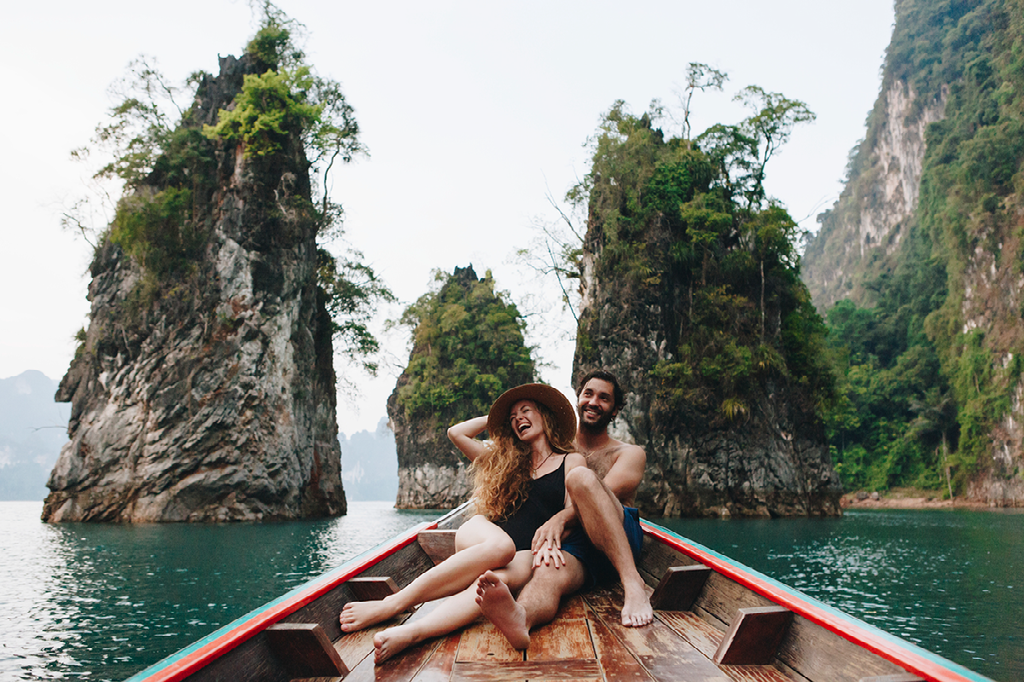 A man and a woman are sitting in a boat on a lake.