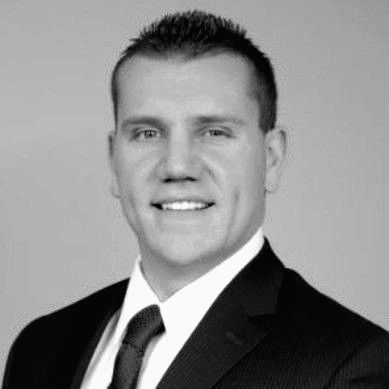 Man in suit, smiling, headshot.