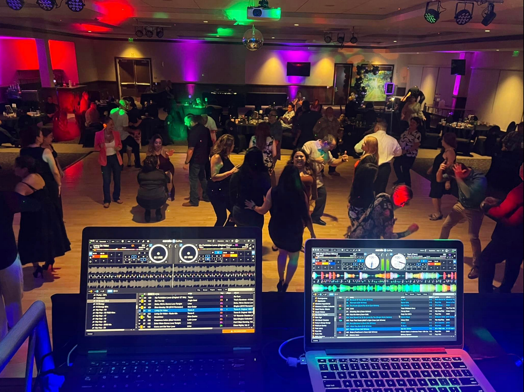 DJ setup with laptops in front; people dancing at a party with colorful lights.
