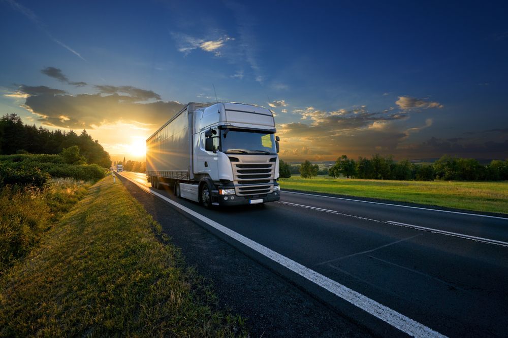 White Trucks Arriving on the Asphalt Road in Rural Landscape in the Rays of the Sunset — Container, Machinery & General Freight Transport in Atherton, QLD