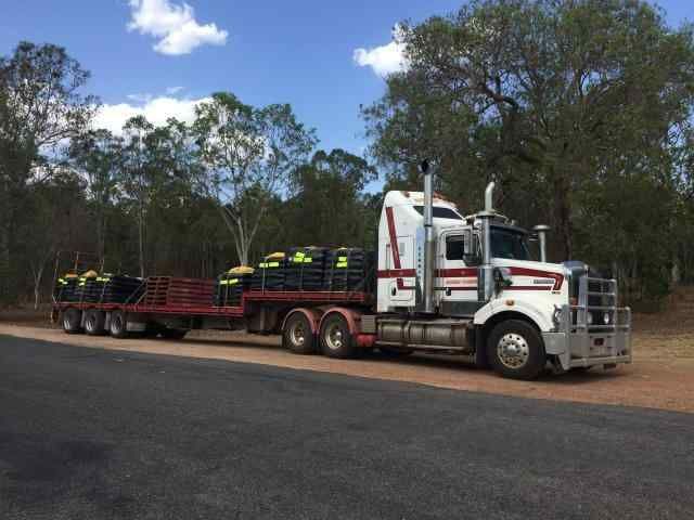 A Truck With a Trailer Carrying Black Bags — Reliable Machinery Transport in Mareeba, QLD