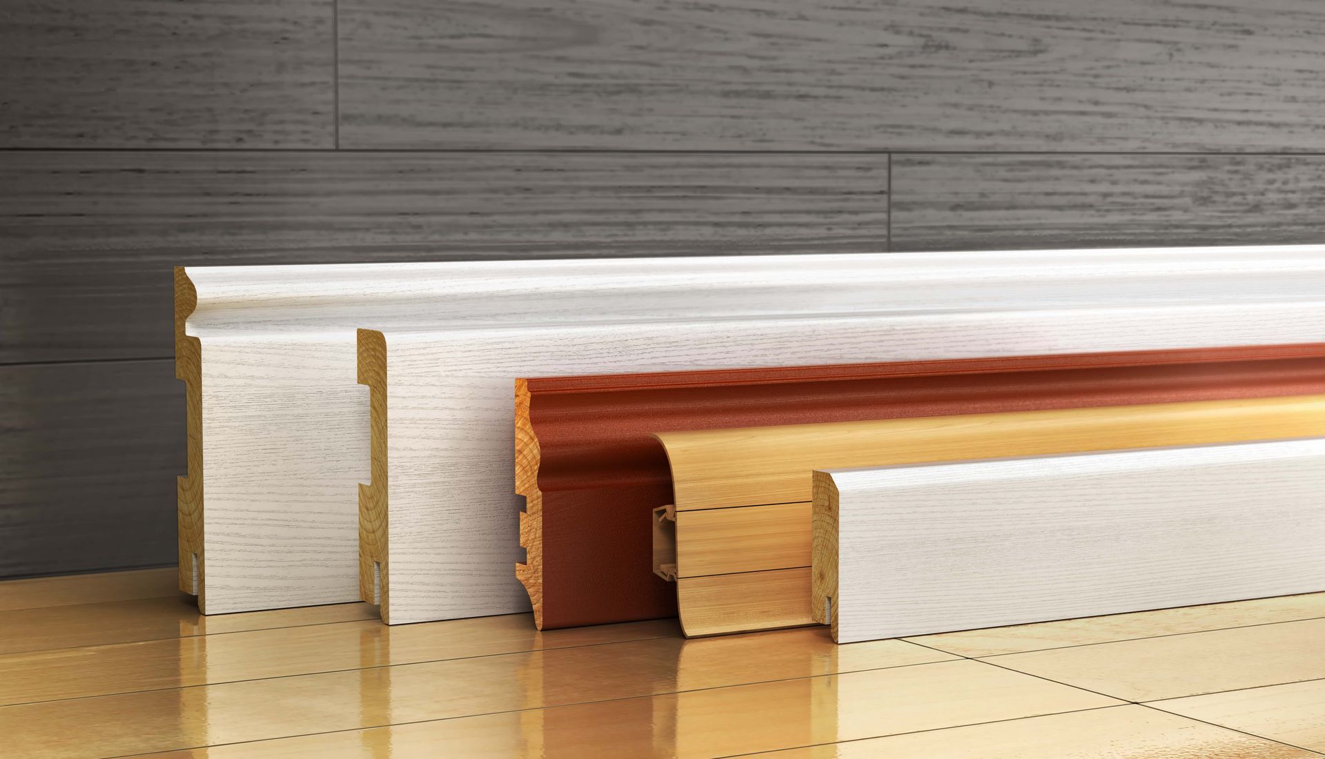 Row of layered wood trim samples in white, tan, and reddish brown on a reflective tabletop.