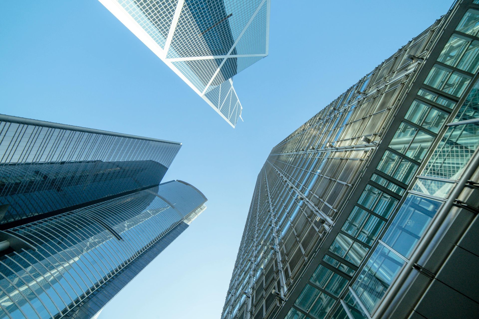 Skyscrapers reaching toward a bright blue sky; modern architecture.