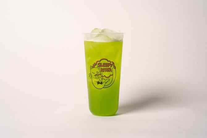 Tall iced milkshake topped with whipped cream and caramel drizzle on a pastel background