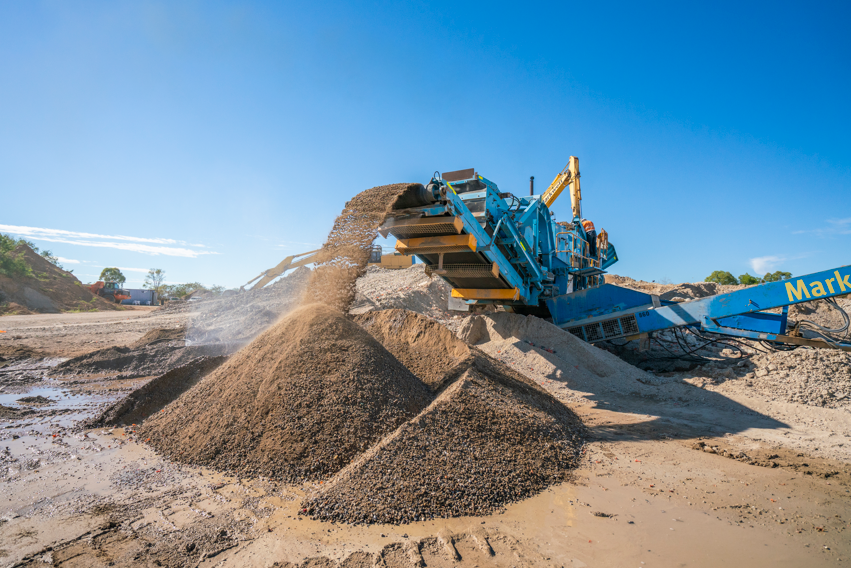 A pile of dirt is being loaded into a truck.