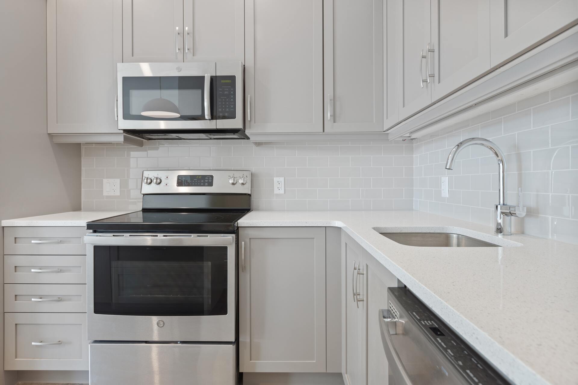 A kitchen with a stove , microwave , sink and dishwasher.