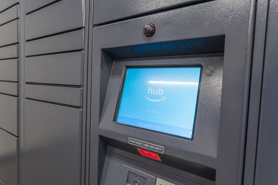 Blue Amazon Hub parcel locker touchscreen embedded in a row of gray lockers.