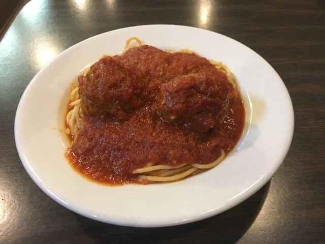 A white plate topped with spaghetti and tomato sauce A white plate topped with spaghetti and tomato sauce