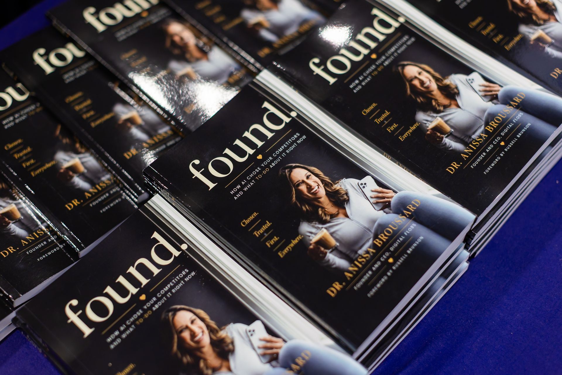 Stack of glossy black magazines with a white “found” cover on a blue surface.