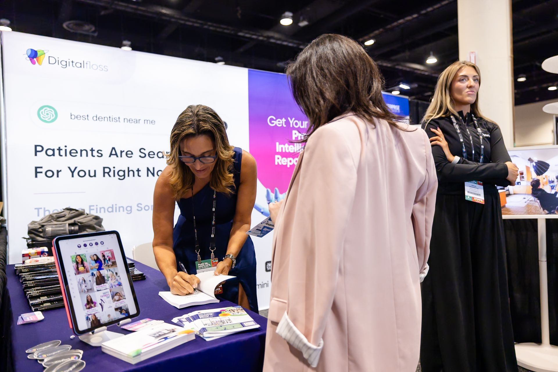 People at a conference booth with informational posters