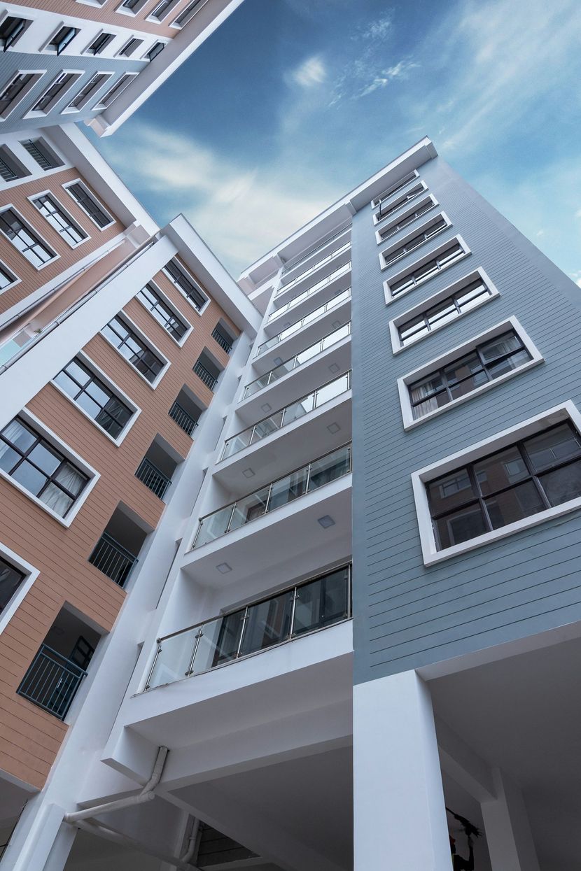 Low-angle view of modern apartment buildings with blue sky between them
