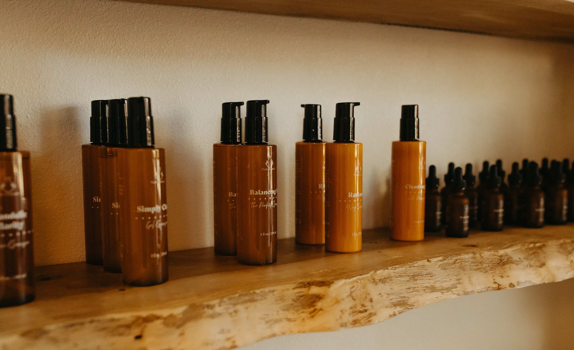 Four brown skincare product bottles with white caps and dispensers.