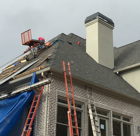 A man is working on the roof of a house