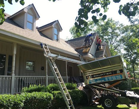 A man is working on the roof of a house.