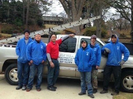 A group of men are posing for a picture in front of a truck.