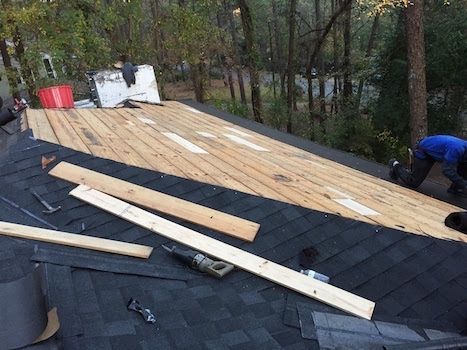A man is working on the roof of a house.