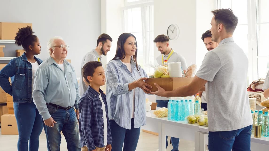 A man is giving a box of food to a woman.
