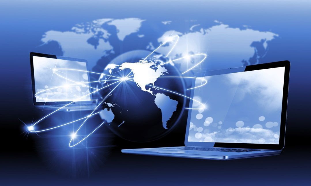 Two laptops with a globe in the background and a map of the world