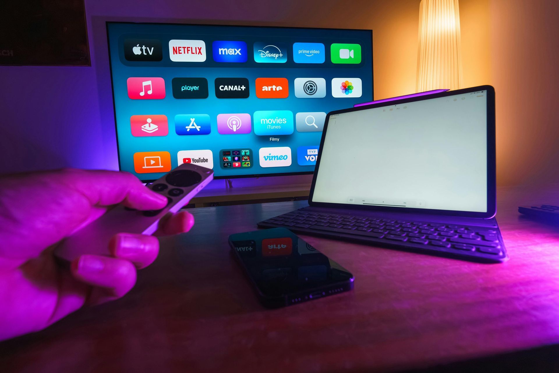 A person is holding a remote control in front of a television.