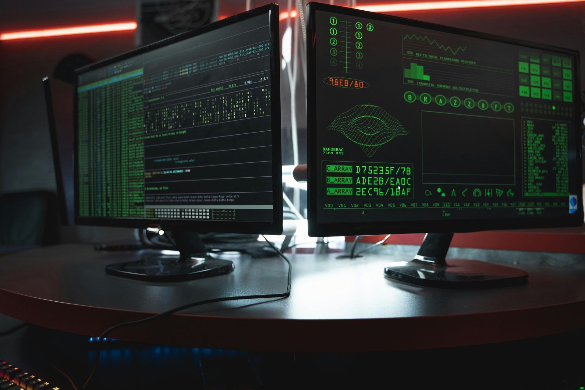 Two computer monitors are sitting next to each other on a table.