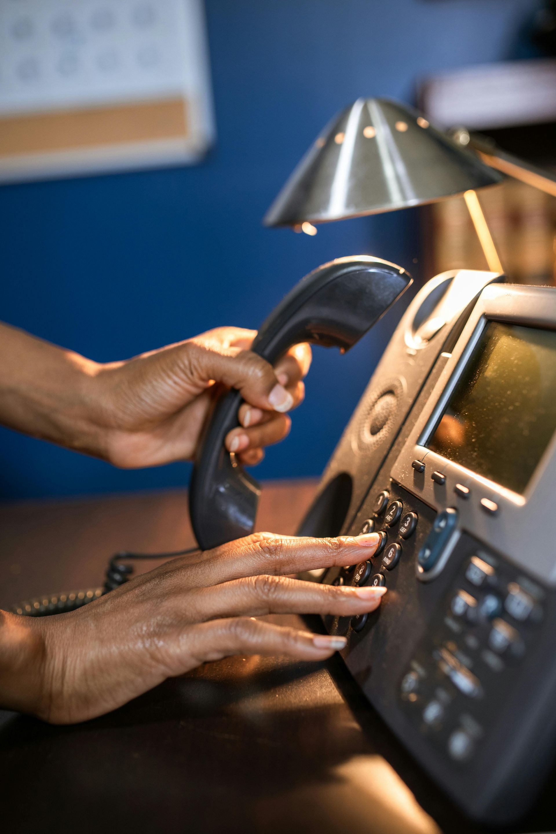 A person is pressing a button on a telephone.