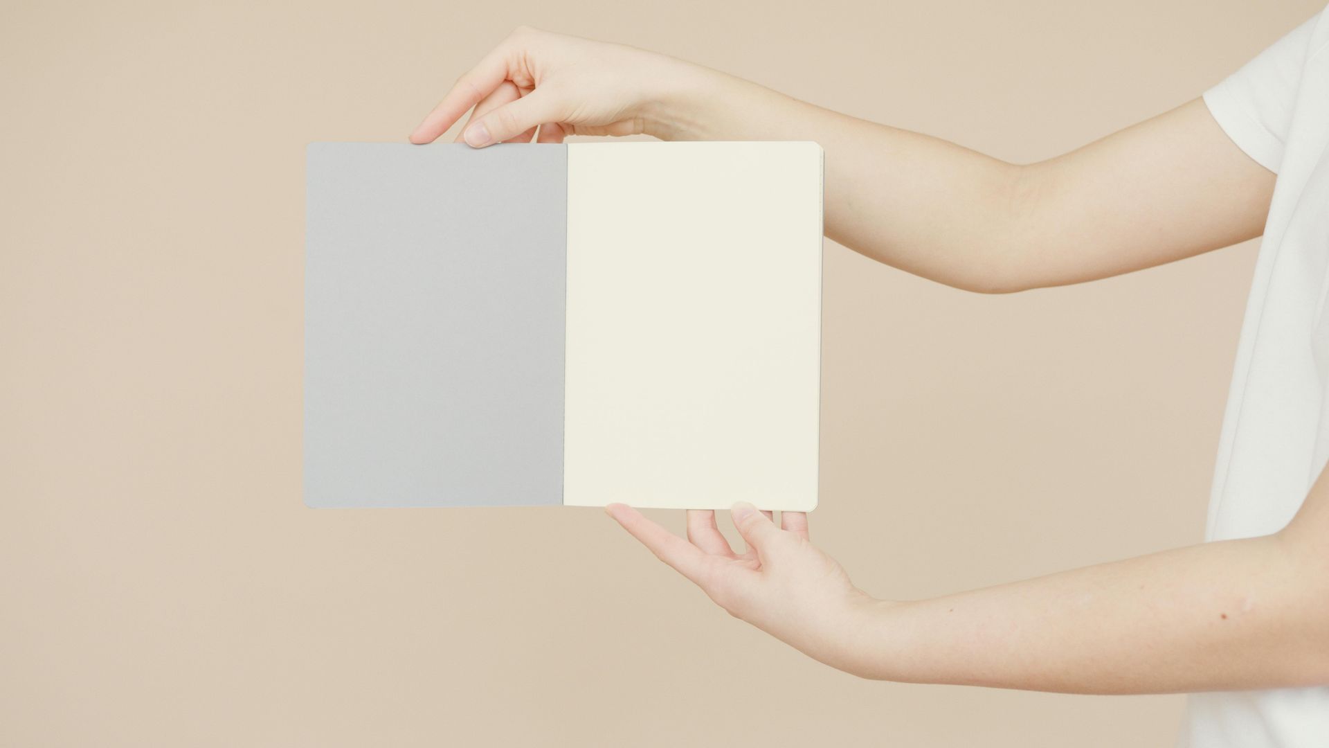 A woman is holding two pieces of paper in her hands.