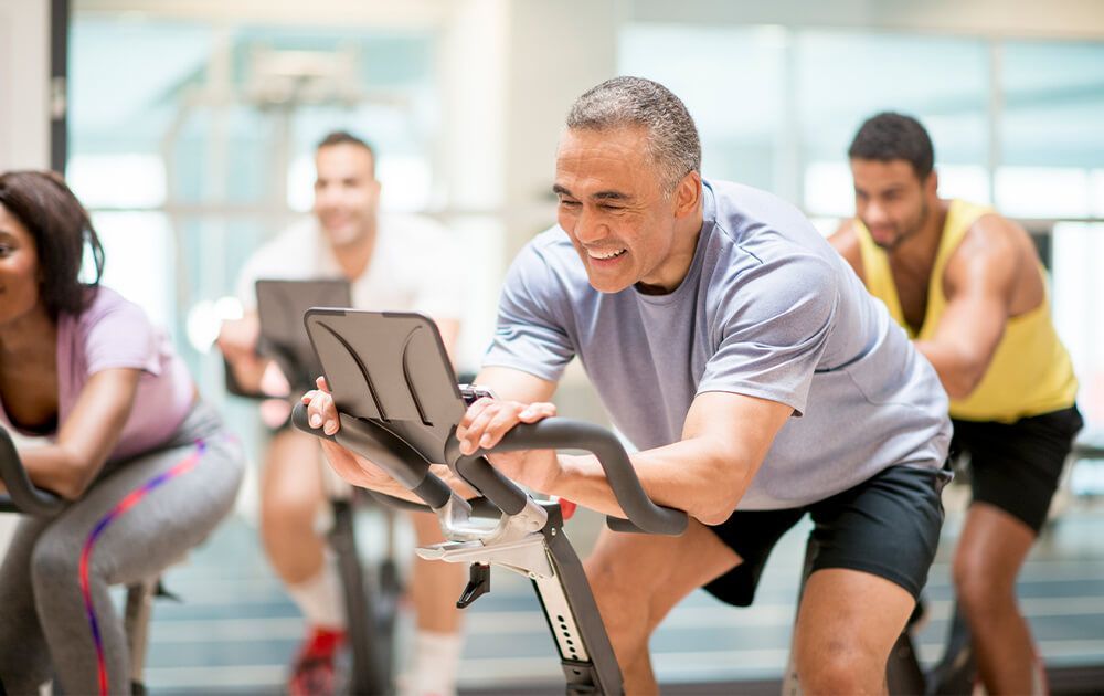 a group of people are riding exercise bikes in a gym