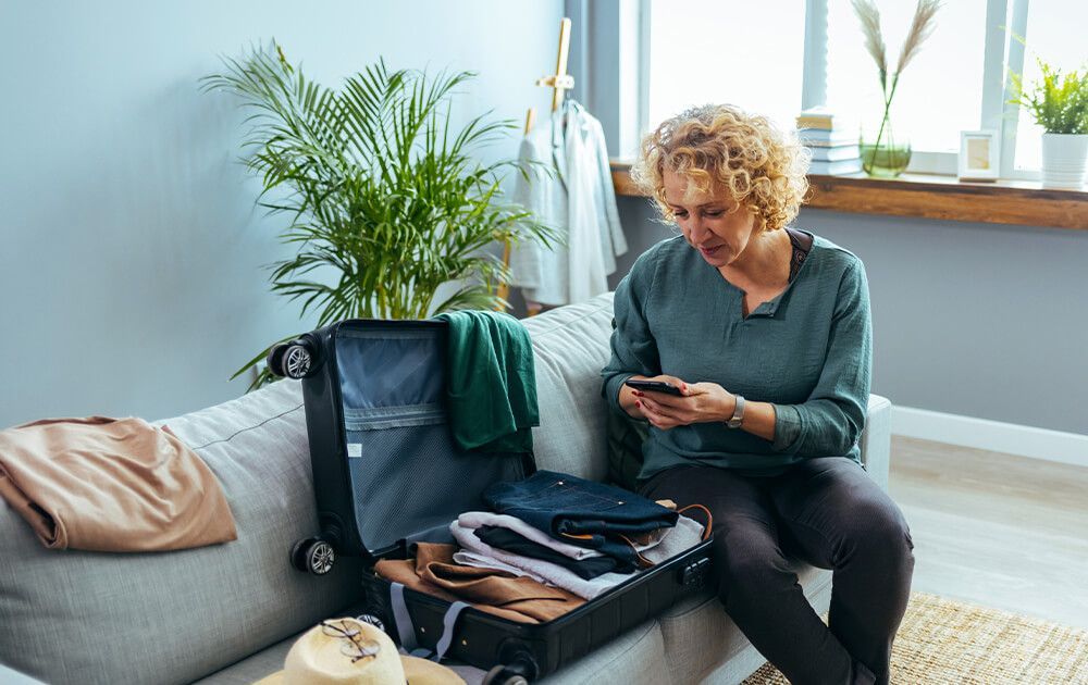 a woman is sitting on a couch looking at her phone