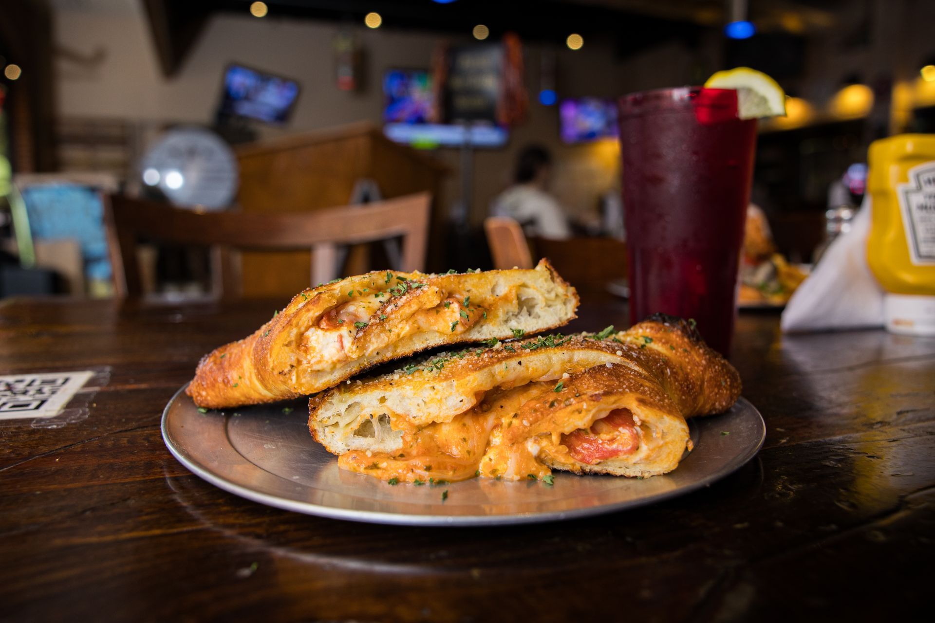 A close up of a pizza calzone on a plate on a table.