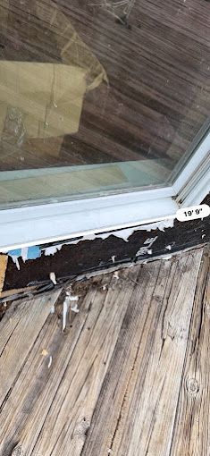 A close up of a window on a wooden deck.
