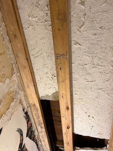 A hole in the ceiling of a building with wooden beams.