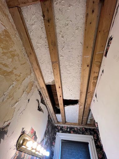 A bathroom with a wooden ceiling and a light fixture