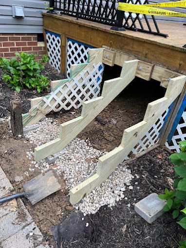 A wooden staircase is being built under a deck.