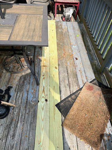 A wooden deck with a table and chairs on it.
