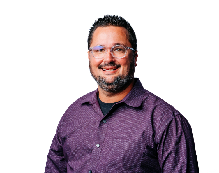 Smiling person in glasses wearing a purple shirt against a white background