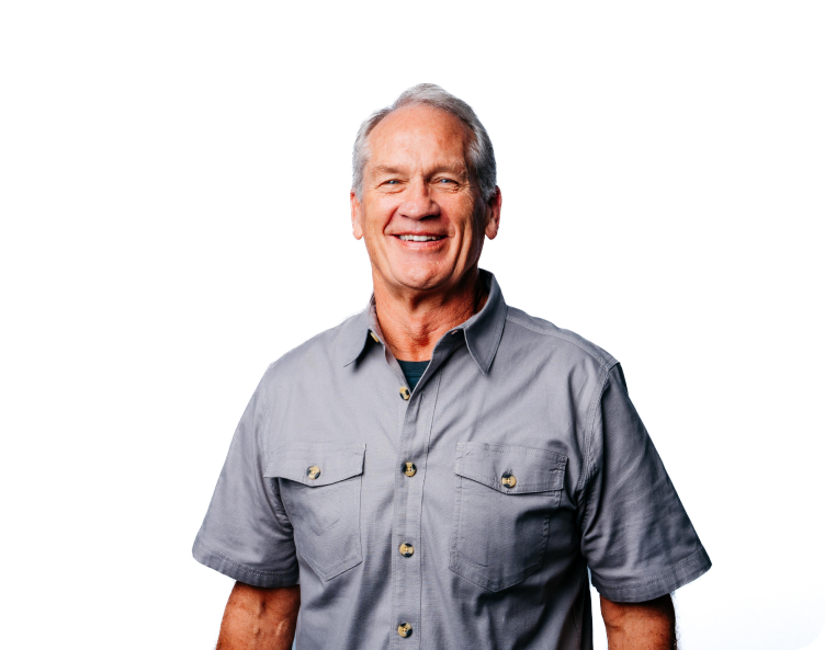 Smiling person in a gray short-sleeve button-up shirt against a white background