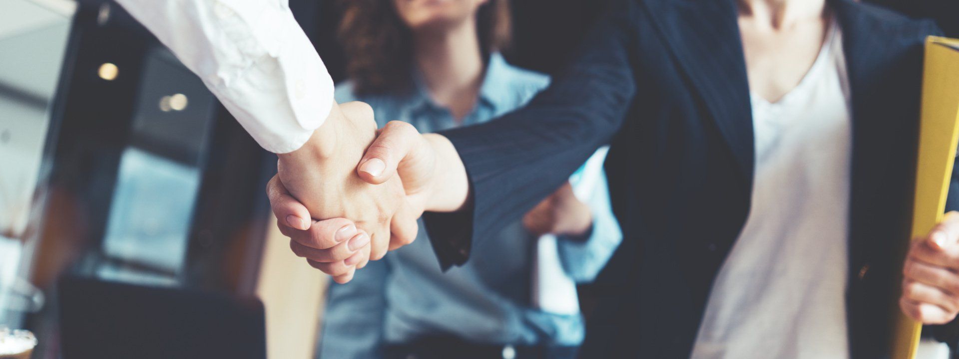 A group of business people are shaking hands in an office.