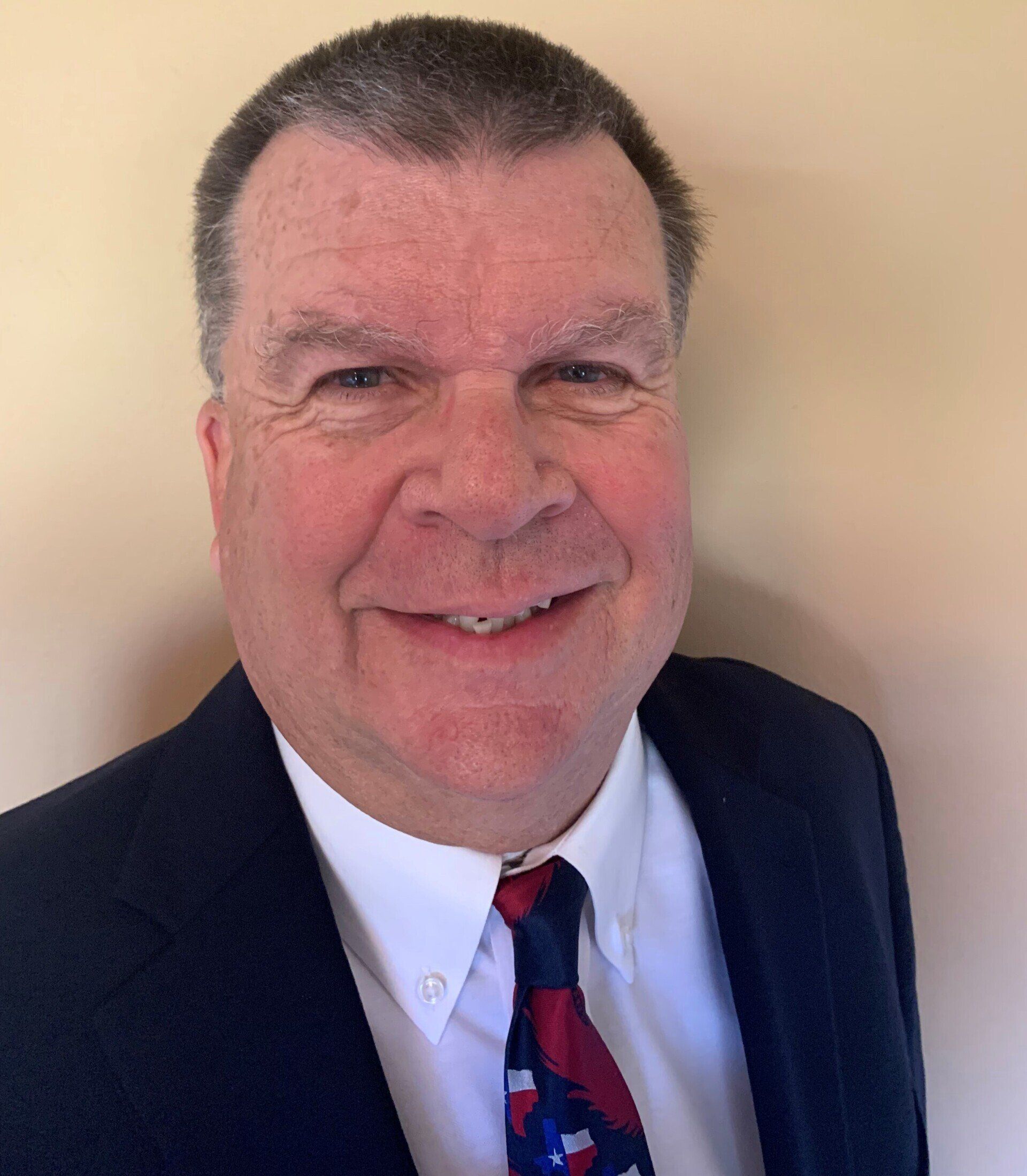 A man in a suit and tie is smiling for the camera