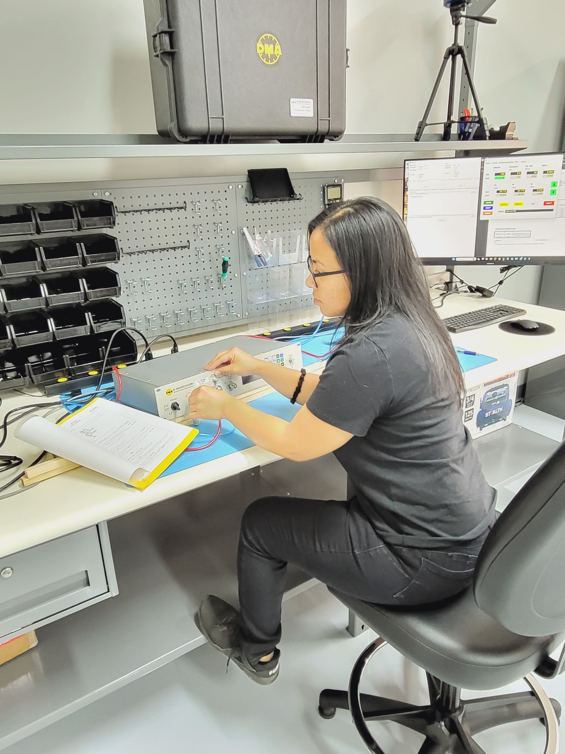 A woman is sitting at a desk working on a computer.