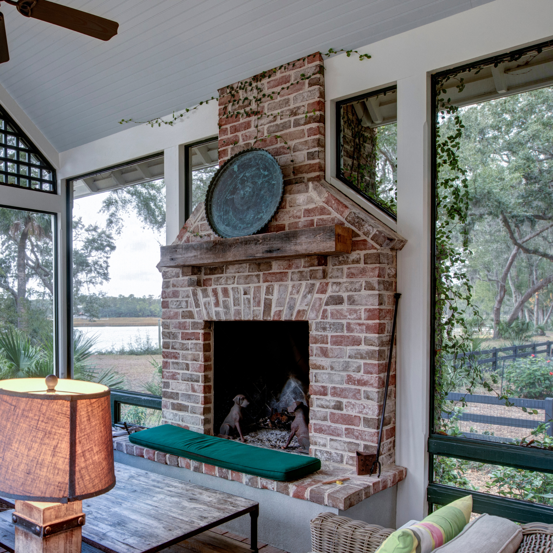 A living room with a brick fireplace and a lamp