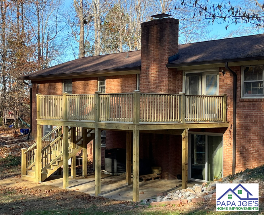 A brick house with a wooden deck and stairs.