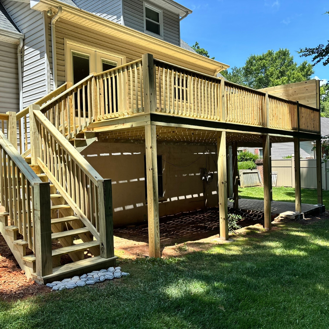 A wooden deck with a railing and trees in the background.