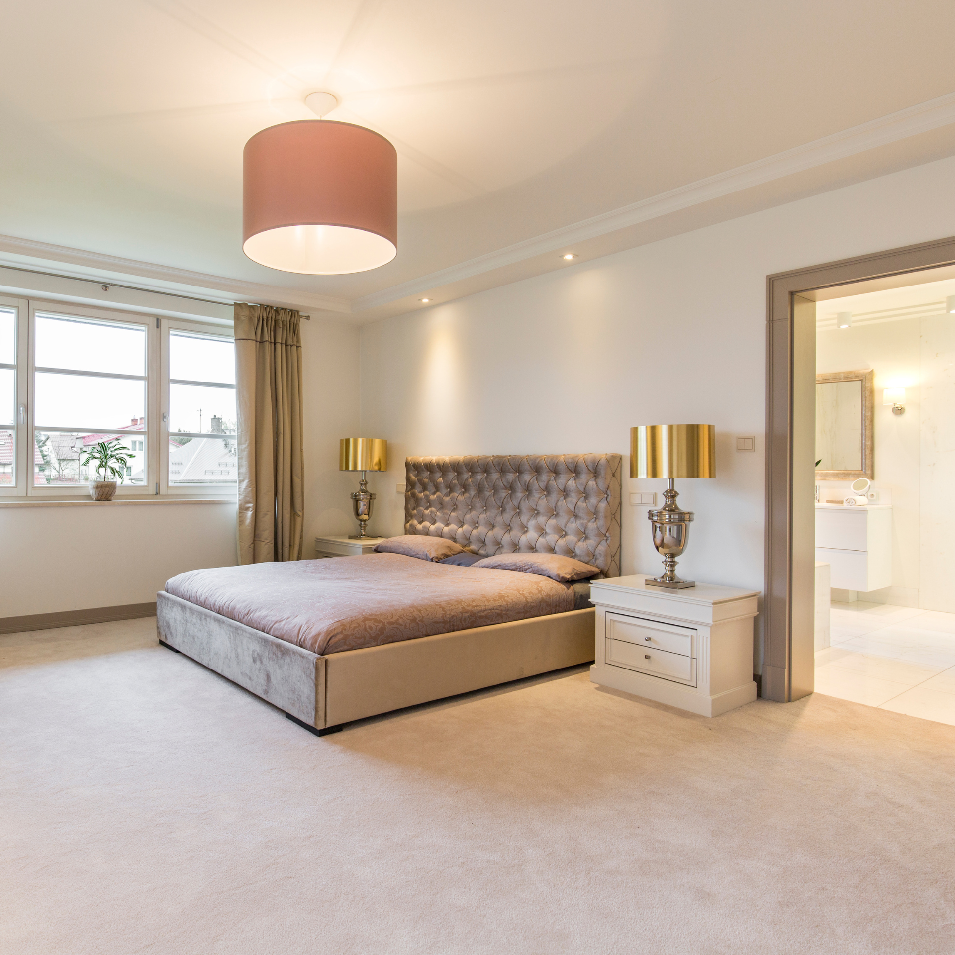 A bedroom with a large bed and two lamps