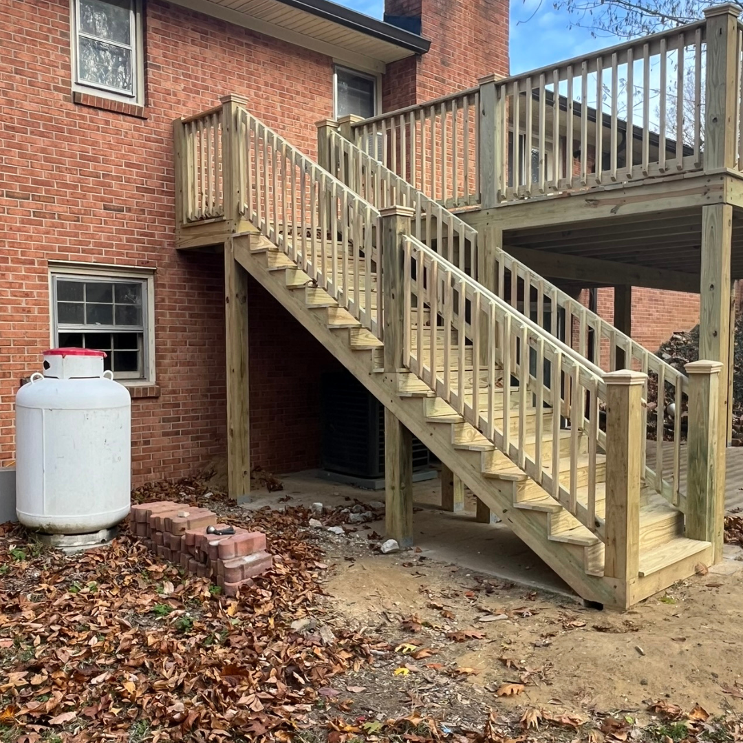 A brick house with a wooden deck and stairs