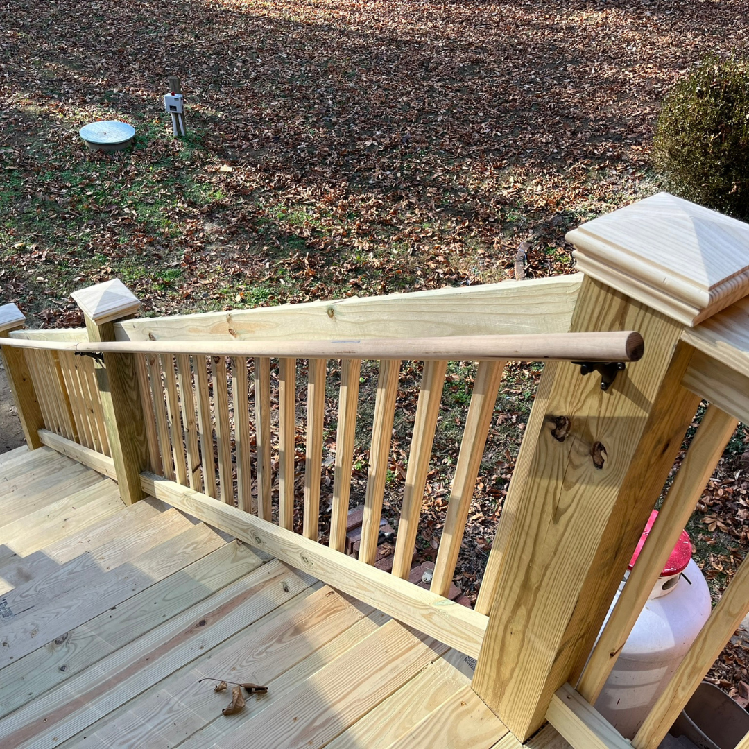 A wooden deck with a wooden railing and stairs