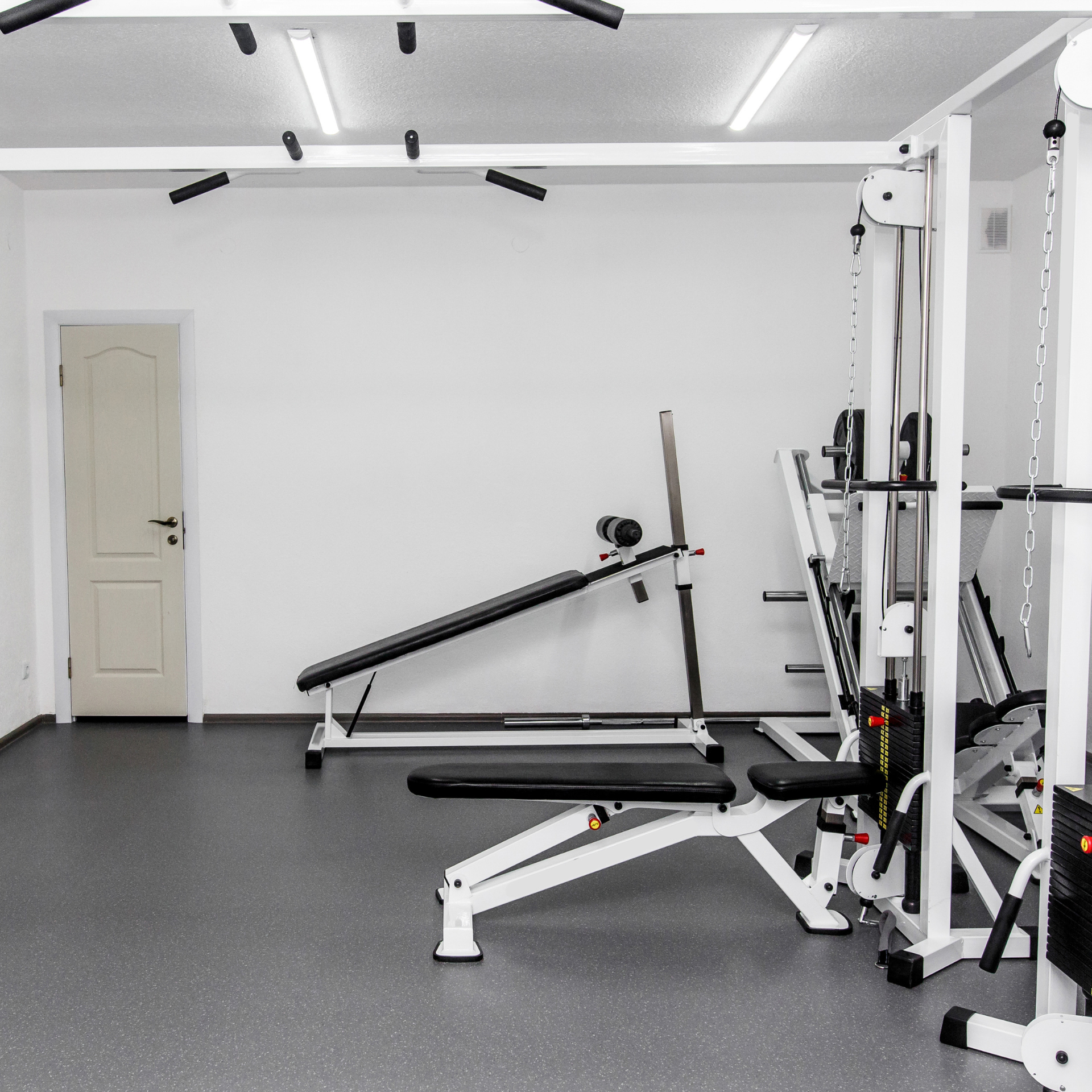A gym with a treadmill and a bench