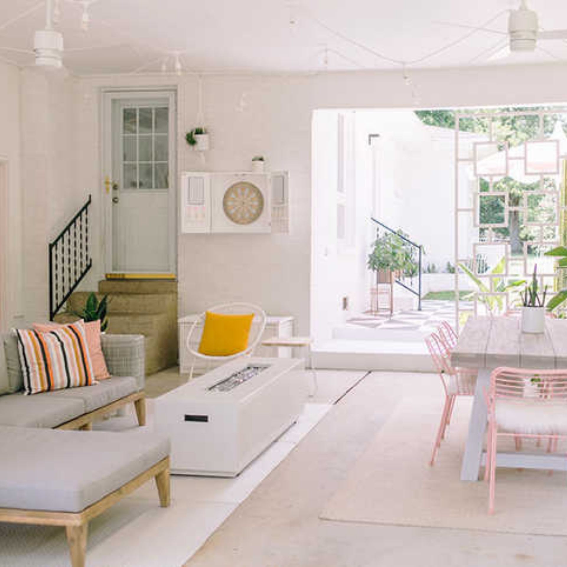 A living room with a couch , chairs , a table and a fireplace.