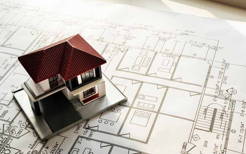 A model house is sitting on top of a blueprint.