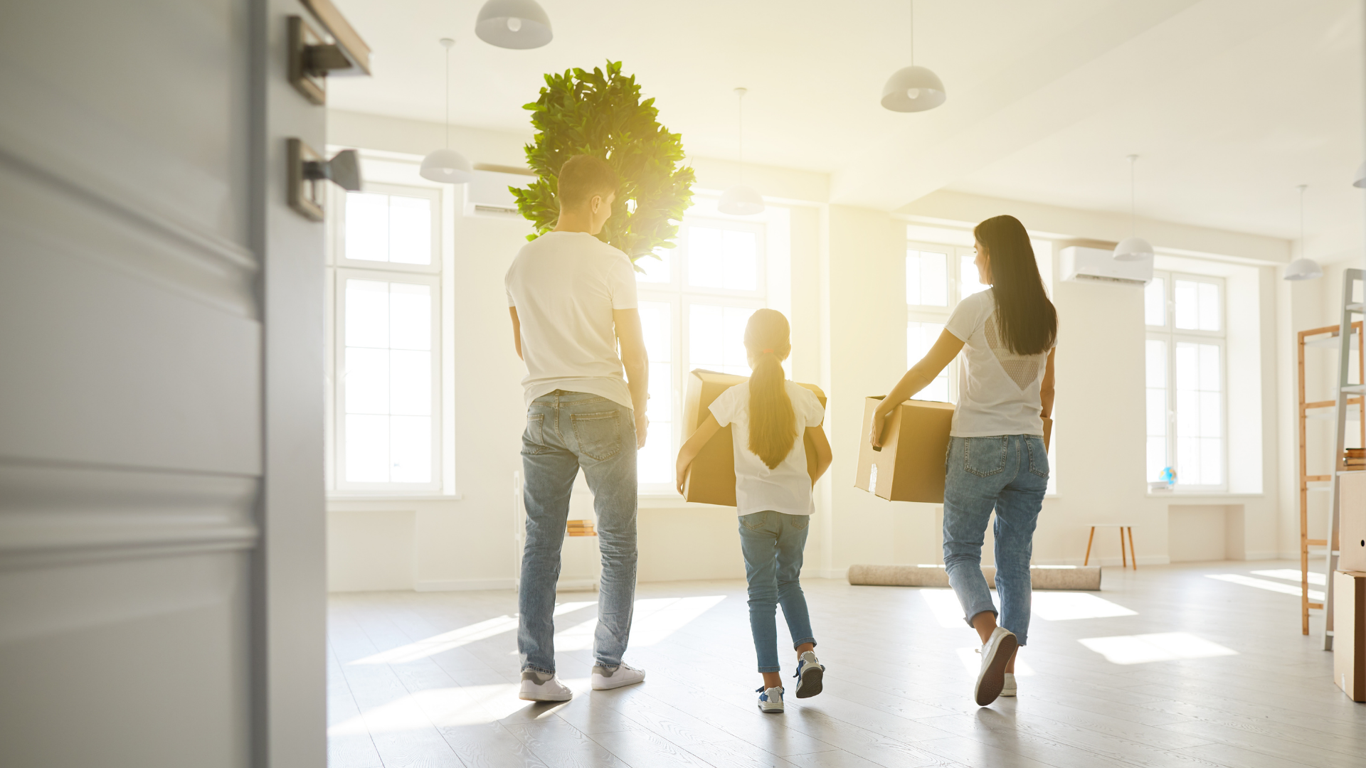 Three people dancing in a bright, empty room with sunlight streaming through the windows.