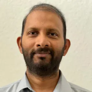 Portrait of a smiling man with a beard against a light background